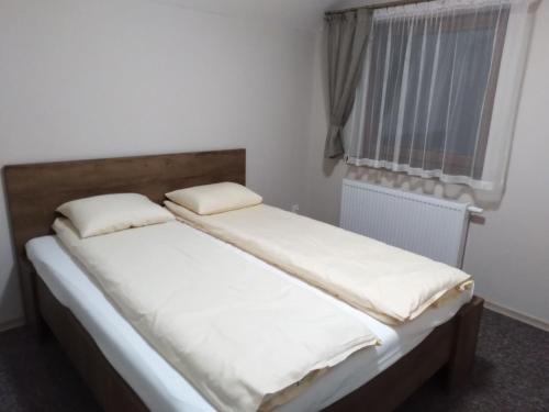 a bed with two pillows on it in a room at Ośrodek Wczasowy "Wczasy pod gruszą" in Biecz