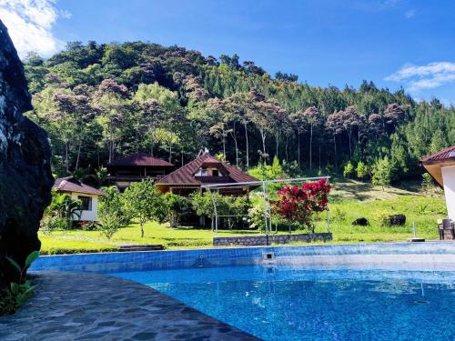 un complejo con piscina frente a una montaña en Mercedes Lodge, en San Ramón