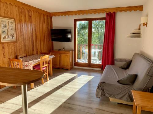 a living room with a couch and a table and a dining room at La Source Blanche Saint Jean Montclar in Saint-Jean Montclar