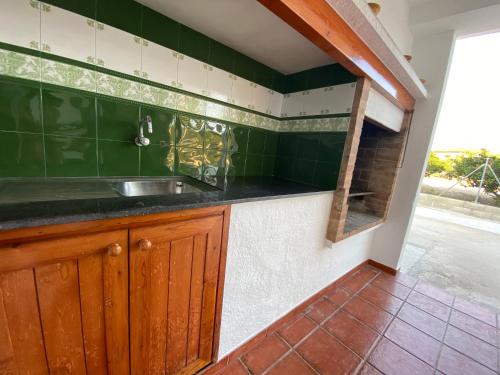a kitchen with a sink and green tiles at Allotjament lo Ribé in Deltebre