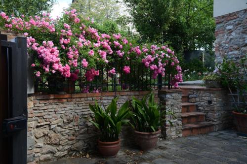 a brick fence with pink flowers on it at Casa1 in Monsummano
