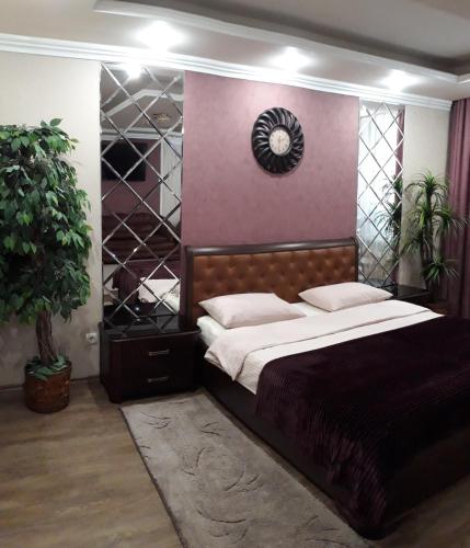 ein Schlafzimmer mit einem großen Bett und einer Uhr an der Wand in der Unterkunft Apartment in a New House in Krementschuk