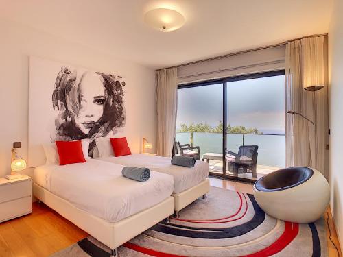 ein Schlafzimmer mit einem Bett und einem großen Fenster in der Unterkunft Villa Vitoria - by LovelyStay in Funchal