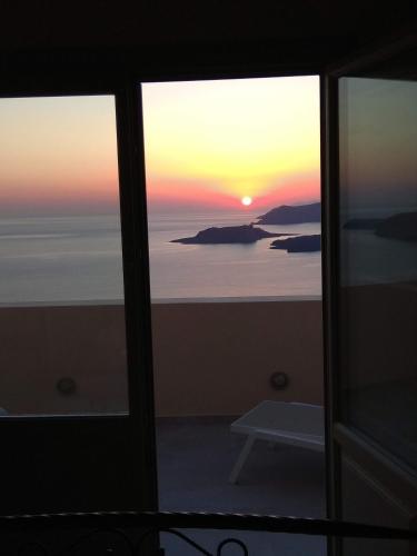 a view of a sunset from a window at Santa Rinoula Suites Sea Sunset views Adults only in Megalokhori