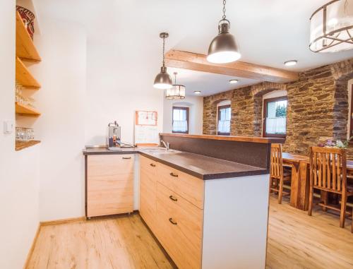 a kitchen with a counter and a dining room at Chata Krušnohorka in Kovářská