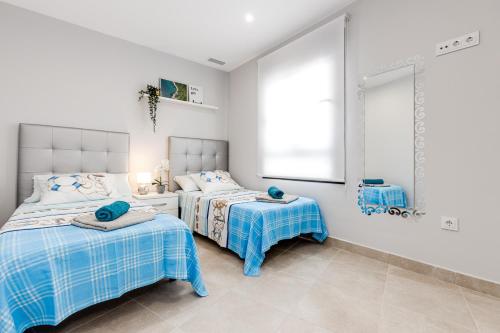 a bedroom with two beds and a mirror at Moderno Apartamento SCANDIC, Playa Del Cura in Torrevieja