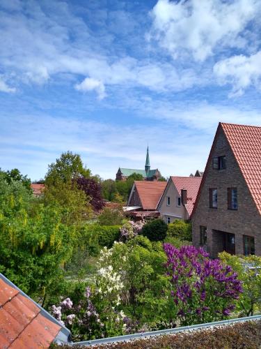 a view of a garden with flowers and buildings at Münsterblick in Bad Doberan