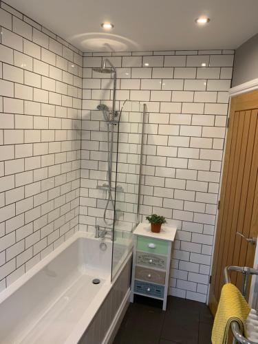 a white bathroom with a tub and a sink at Withens Way Holiday Cottage, 2 Bedrooms, Haworth in Haworth