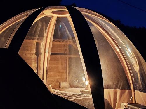un igloo avec une fenêtre la nuit dans l'établissement Le Wigwam du Fassac, à Saint-Julien-du-Puy