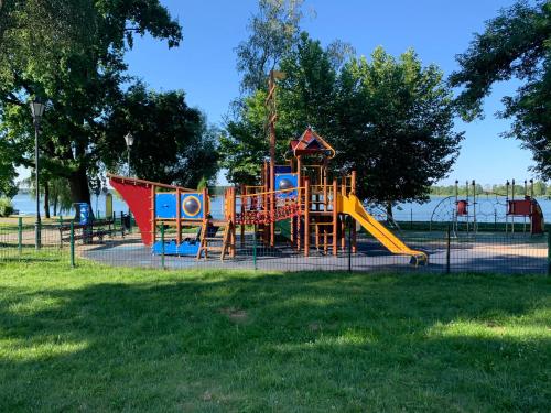 une aire de jeux avec un toboggan dans un parc dans l'établissement Marina Blue-Apartament przy promenadzie, à Ełk