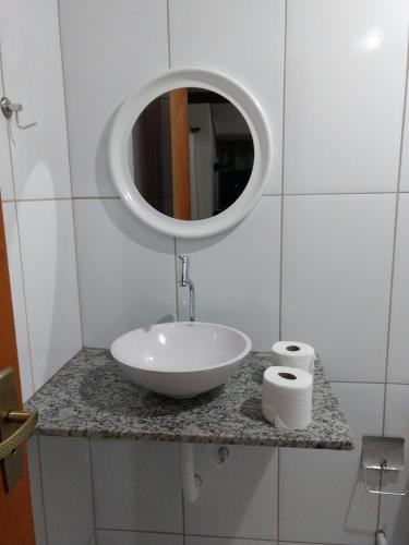 a bathroom with a sink and a mirror on a counter at Lumiar Chalé Jardim do Sossego in Lumiar