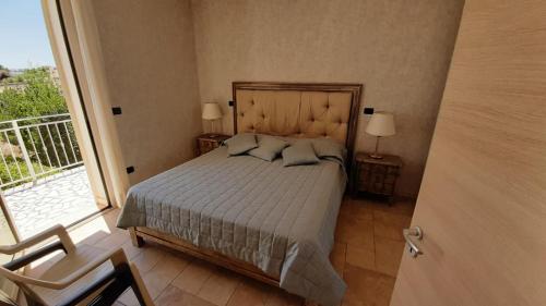 a bedroom with a bed and a large window at Lucrezia relax 2 in Nardò