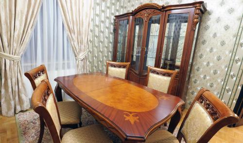 a wooden table with chairs and a wooden cabinet at Garden Hall in Ternopilʼ