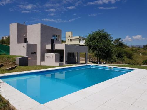 a swimming pool in front of a house at Bº CERRADO LOMAS DEL REY MAYU SUMAJ in San Antonio de Arredondo