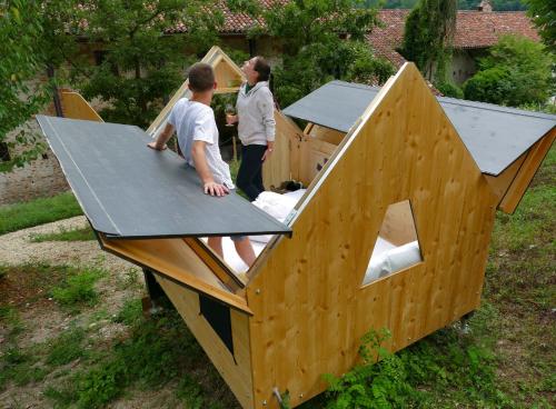 two children standing in a wooden dog house at Casa Baladin camere di Charme e Agronidi dell'Open Garden in Piozzo
