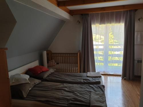 sypialnia z łóżkiem i dużym oknem w obiekcie Dom na Wzgórzu w Andrychowie