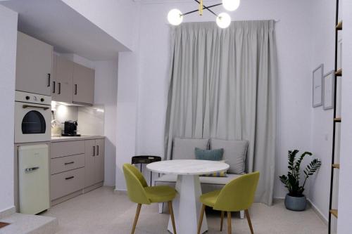 a white kitchen with a table and chairs in a room at The Well View in Preveza