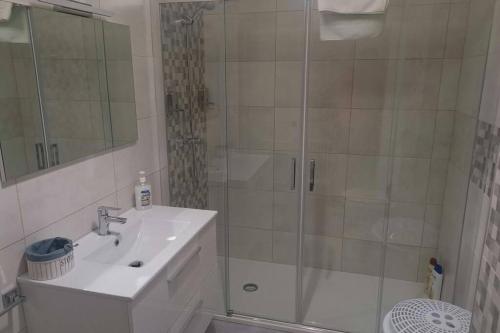 a white bathroom with a shower and a sink at Apartamento Lalín Centro ll in Lalín