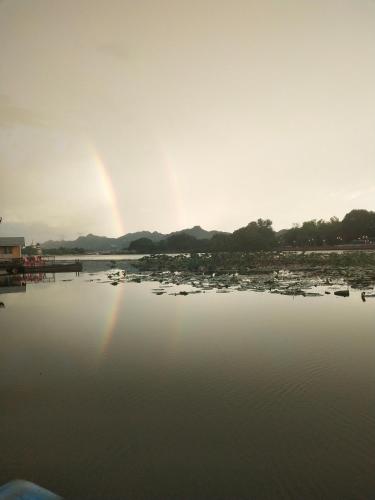 a rainbow in the sky over a body of water at Tamarind Guesthouse in Kanchanaburi