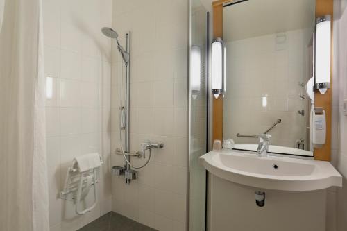 a white bathroom with a sink and a shower at ibis Le Mans Est Pontlieue in Le Mans