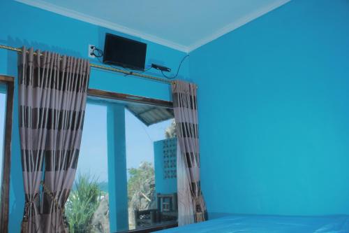 Habitación con ventana grande y TV. en Omah Sundak Homestay, en Tepus
