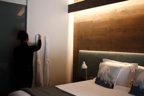 a person standing in a room next to a bed at Astra Falls Creek in Falls Creek