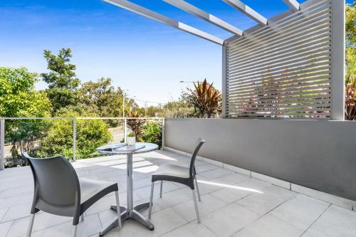 a patio with a table and chairs on a balcony at Essence Apartments Chermside in Brisbane
