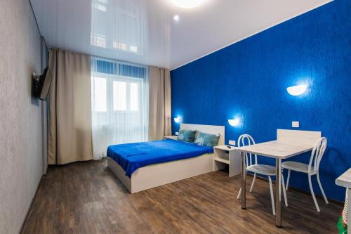 a blue bedroom with a bed and a table at 22-HOTEL in Barnaul