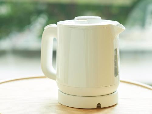 a white electric kettle sitting on a wooden table at Sotetsu Fresa Inn Yokohama Higashiguchi in Yokohama