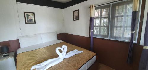 a bedroom with a bed with two white swans on it at Green Canyon Resort in Lamai
