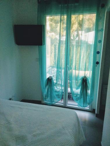 une chambre avec un lit et une fenêtre avec des rideaux bleus dans l'établissement NICE VIEW Jolie Studio avec Jardin, à Nice