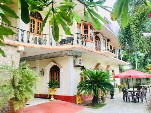 a building with a balcony and a table and chairs at Senthil Complex in Jaffna