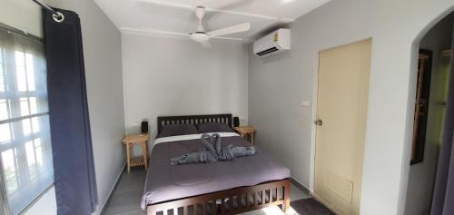 a bedroom with a bed with a ceiling fan at Green Canyon Resort in Lamai