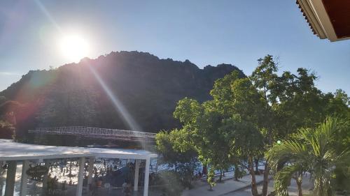 Blick auf einen Berg mit Bäumen und die Sonne in der Unterkunft Vạn Xuân Royal Hotel in Ninh Bình