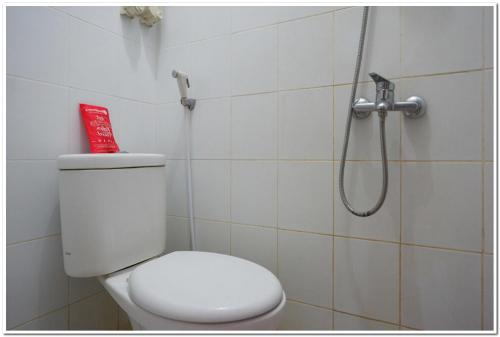 a bathroom with a toilet and a shower at RedDoorz near Jogja Expo Center 2 in Yogyakarta