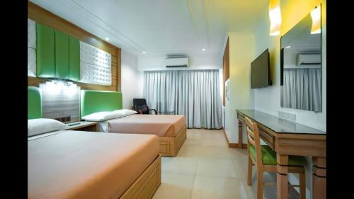 Cette chambre comprend deux lits et un bureau. dans l'établissement Paladin Hotel, à Baguio