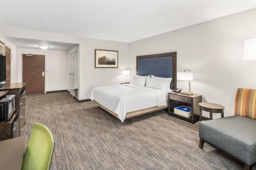 a large hotel room with a bed and a couch at Holiday Inn Express & Suites Wilmington-Newark by IHG in Newark