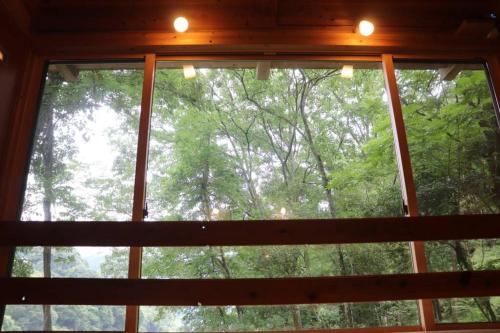 a window in a room with a view of trees at YAMAYA BASE 2 in Miyoshi