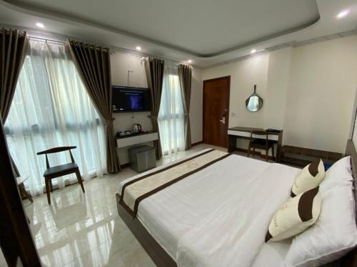 a bedroom with a large bed and a desk at SEN HIDDEN CHARM in Con Dao
