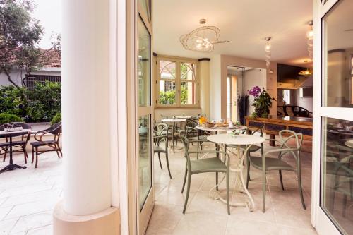 a patio with tables and chairs and a dining room at La Villa Desenzano in Desenzano del Garda