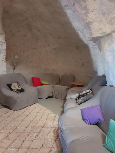 a living room with a couch and pillows at Fossickers Den Dugout Accommodation in White Cliffs