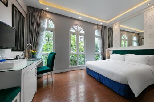 a bedroom with a bed and a desk and a tv at Minerva Church Hotel in Hanoi