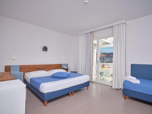 a hotel room with a bed and two windows at Hotel Residence Porto San Paolo in Porto San Paolo