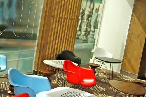 a group of chairs and tables in a room at Ibis Guadalajara Expo in Guadalajara