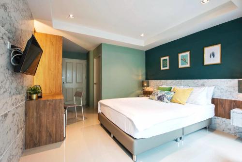 a bedroom with a large bed and green walls at NW Apartment Lasalle 59 in Bangna