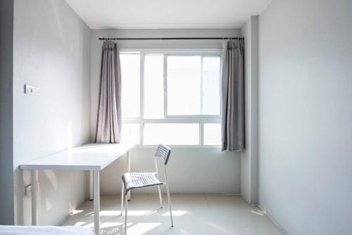 班納的住宿－拉塞爾59NW公寓式酒店，窗户客房内的白色桌子和椅子