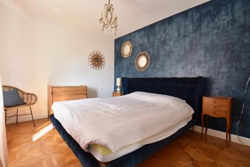 - une chambre avec un lit et un mur bleu dans l'établissement Villa 7 chambres avec grande piscine non chauffée à 600 m de la plage, à Royan