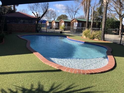 a swimming pool with a brick border in a yard at BIG4 Albury Tourist Park in Albury