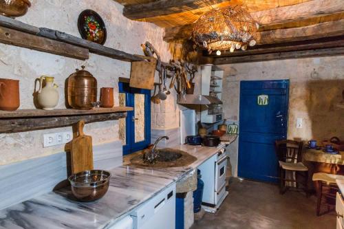 uma cozinha com um lavatório e um frigorífico azul em Apo Petra em Agia Marina