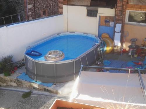 un grand bain à remous dans une arrière-cour avec dans l'établissement Le Pressoir, à Saint-Julien-de-Coppel